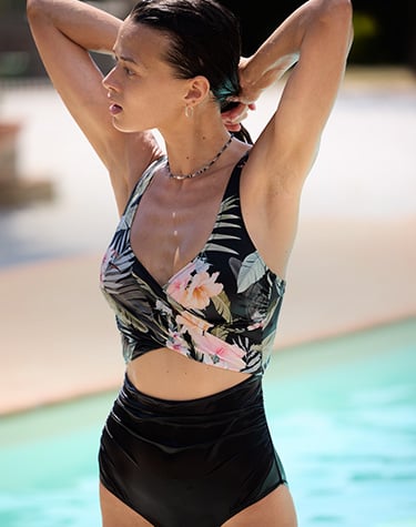  Woman wearing a one-piece swimsuit with a crossed front and belly cutout, from Everyday Sunday. 