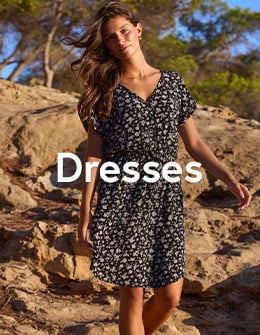 Woman in a black dress with white floral print, from Tropik. 