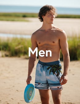 Man in volley swim shorts with palm tree and beach print, from Hamabe. 