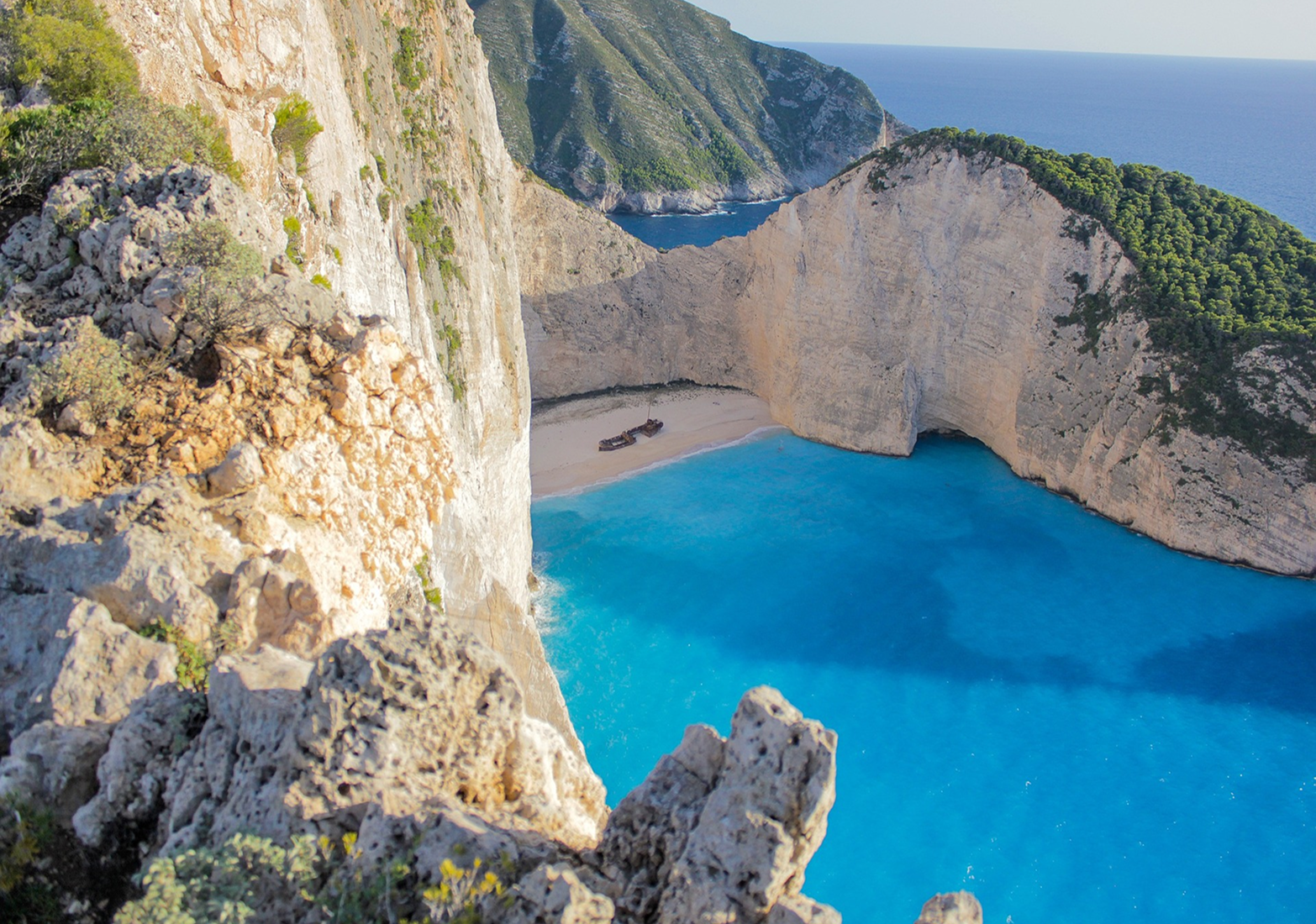 The white cliff beach and its beached boat at Navagio, Greece. Image by summerstock on Pixabay.