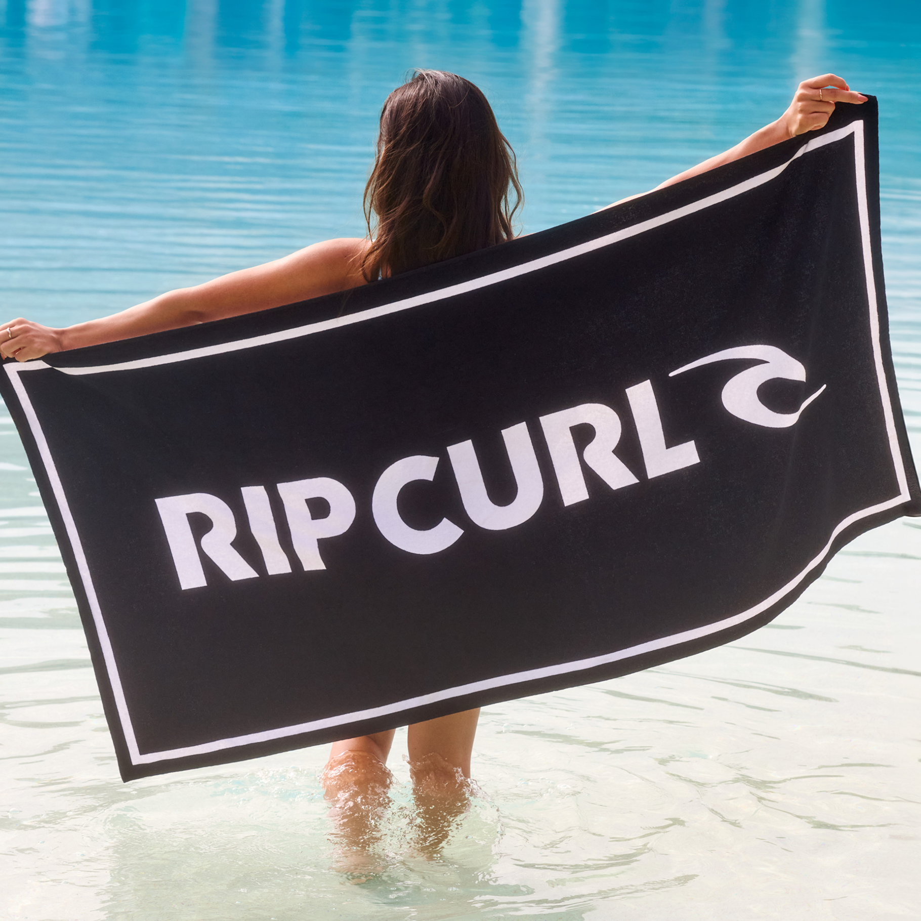 A woman with a beach towel from Rip Curl – Bikini Village 